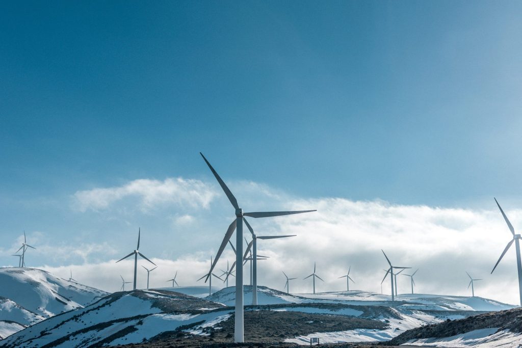 wind turbines on snowy mountain under clear blue sky during daytime